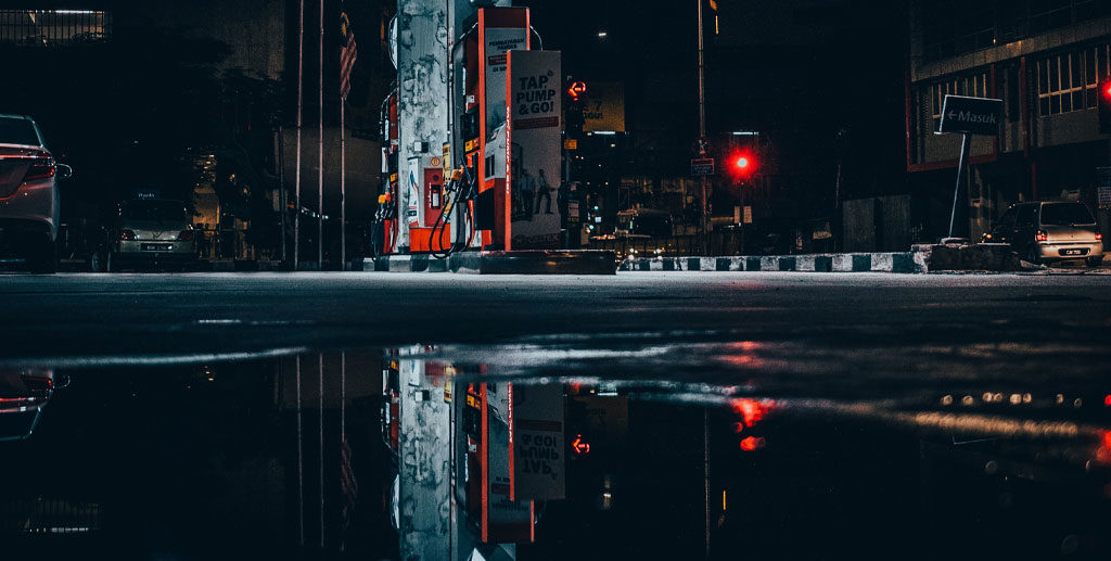 Cars at petrol station at night in the rain